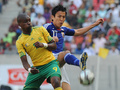 サッカー国際親善試合、南アフリカ対日本。南アフリカのカトレゴ・アベル・ムフェラ（Katlego Abel Mphela）とボールを競る長谷部誠（Makoto Hasebe、2009年11月14日撮影）(c)AFP/ALEXANDER JOE
