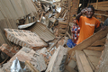 2008年2月3日、コンゴ（旧ザイール）中部ブカブ（Bukavu）で、地震の影響で建物が倒壊した市場のがれきの上で叫ぶ男性ら。(c)AFP/LIONEL HEALING