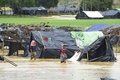 バングラデシュ・ウキア県の難民キャンプで、あふれた水を歩いて渡るロヒンギャ難民たち（2017年9月20日撮影）。(c)AFP/DOMINIQUE FAGET