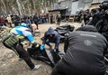 ウクライナの首都キーウ近郊ブチャで、一部が燃やされた6人の遺体を収容する警察や市当局者（2022年4月5日撮影）。(c)Genya SAVILOV / AFP