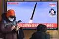 韓国ソウルの駅で、テレビで放送される北朝鮮のミサイル発射実験の資料映像を見る人（2022年1月5日撮影）。(c)Jung Yeon-je / AFP