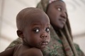 イスラム過激派組織ボコ・ハラムに追われた国内避難民（IDP）が暮らすナイジェリア・ボルノ州ディクワのキャンプで、国連児童基金（ユニセフ）が運営するクリニックを訪れた母子（2014年2月14日撮影）。(c)AFP/FLORIAN PLAUCHEUR