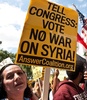 米ワシントンD.C.（Washington D.C.）市内で、シリア軍事行動を承認しないよう米議会に求めるプラカードを掲げたデモ参加者（2013年9月7日撮影）。(c)AFP/Nicholas KAMM
