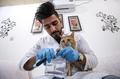 イラク南部の都市バスラにオープンした国内初の猫専用ホテルで、猫の爪を切る獣医学生のアフマド・ターヘルさん（2018年3月28日撮影）。(c)AFP PHOTO / HAIDAR MOHAMMED ALI