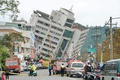 台湾東部・花蓮で、地震により傾いたビルの周辺の道路を封鎖する救助隊（2018年2月7日撮影）。(c)AFP PHOTO / PAUL YANG