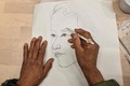 中国・上海にあるイケアのカフェテリアで別の参加者の似顔絵を描く男性（2023年12月5日撮影）。(c)Hector RETAMAL / AFP