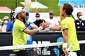 全豪オープンテニス、男子シングルス1回戦。試合後にラドゥ・アルボット（左）と握手を交わす西岡良仁（2022年1月17日撮影）。(c)Paul Crock / AFP