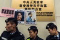 香港の中央政府駐香港連絡弁公室に貼られた行方不明になっている出版社の社員らの顔写真（2016年1月3日撮影）。(c)AFP/ANTHONY WALLACE