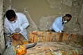 エジプト南部ルクソール近くの3500年前の墓で見つかった木棺を前に作業する同国考古学チームのメンバー（2017年4月18日撮影）。(c)AFP