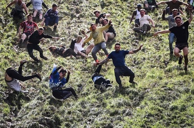 転がるチーズ追いかけ参加者もコロコロ 英国の恒例行事