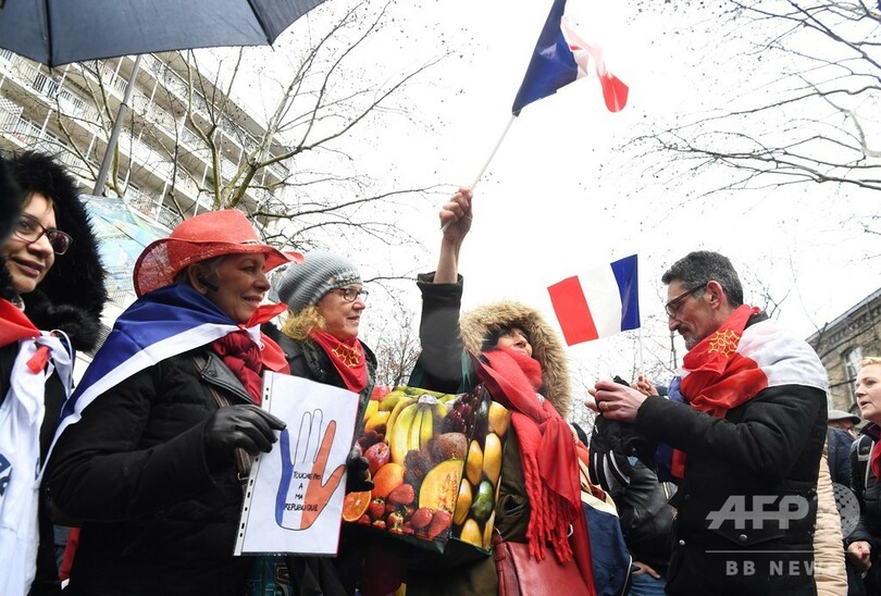 パリで「赤いスカーフ」隊がデモ 「黄色いベスト」の暴力に1万人超が抗議