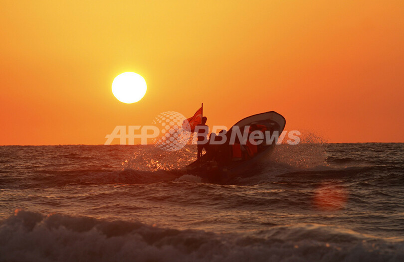 パレスチナのビーチ、夕暮れを背に夏を楽しむ人々