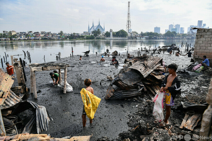 マニラ湾口近くの無認可居住地で火災、潮水に漬かる住民 フィリピン
