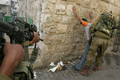 2008年4月13日、パレスチナ自治区ヨルダン川西岸（West Bank）のヘブロン（Hebron）で、パレスチナ人少年の身体検査を行うイスラエル兵。(c)AFP/HAZEM BADER