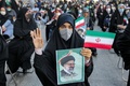 イランの首都テヘランのイマーム・フセイン広場で開かれたエブラヒム・ライシ師の大統領当選を祝う集会に参加し、ライシ師の写真を手にした女性（2021年6月19日撮影）。(c)ATTA KENARE / AFP