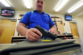 米国でほかの産業界が不況にあえぐ中、唯一活気を帯びているのが銃器業界だが、バラク・オバマ（Barack Obama）大統領は期せずして、この業界の今年一番の「非公式セールスマン」を演じているのかもしれない。

　オバマ政権が水面下で銃所持に関する規制強化を計画しているとの観測や、不況で犯罪が増えるとの懸念から、銃や弾丸を買いだめておこうとする動きが米国で現れている。

　写真は、米カリフォルニア（California）州南部のエルカホン（El Cajon）の射撃練習場「Project Y2000」で自分が経営する銃器店で、ハンドガンを取り出すマネージャー（2009年4月21日撮影）。(c)AFP/Jewel SAMAD