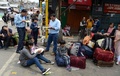 インド東部・西ベンガル州ダージリンで、警察とゼネスト参加者らの衝突を受け、地元当局が用意した避難用のバスを待つ間に食料を受け取る観光客ら（2017年6月9日撮影）。(c)AFP/DIPTENDU DUTTA