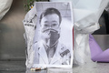 中国の武漢中心医院の系列施設の前に置かれた李文亮医師の写真（2020年2月7日撮影）。(c)AFP