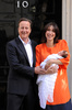 英ロンドンの首相官邸前で、生まれたばかりの娘を抱く妻のサマンサ氏と共に写真撮影に応じるデービッド・キャメロン首相（2010年9月3日撮影）。(c)BEN STANSALL / AFP