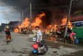 イスラム武装勢力の襲撃を受けたフィリピン南部ミンダナオ（Mindanao）島の商業都市サンボアンガ（Zamboanga）では、12日も治安当局と和平協議に応じないイスラム反政府勢力との戦いが2か所の戦線で続いている。同国政府は、炎に包まれた複数の地区を奪還した。

サンボアンガでは、4日間にわたる戦闘で数千人が避難を強いられている。フィリピン軍報道官によると、同市のサンタカタリナ（Santa Catalina）地区では、治安部隊が進軍する中、家々が炎に包まれた。

警察の支援を受けた少なくとも1500人の兵士が、サンボアンガ郊外のイスラム教徒が多く住む6地区を包囲。これらの地域では、反政府勢力「モロ民族解放戦線（MNLF）」のメンバー約180人が、9日に攻撃を開始して以降潜伏を続けている。反政府勢力は数十人の人々を「人間の盾」にしているため、市民が負傷することを避けたい治安部隊との間でこう着状態が続いている。

写真はサンボアンガで火に包まれる家々の横を、家財道具を持って通り過ぎる地元住民（2013年9月12日撮影）。(c)AFP/TED ALJIBE