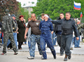ウクライナ東部のドネツク（Donetsk）で、占拠した州政府庁舎の外で目隠しをした男性を連行する親ロシア派の武装勢力（2014年5月5日撮影）。(c)AFP/GENYA SAVILOV