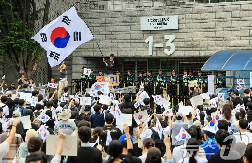 統一地方選挙の投票用紙不足事態に反発した市民が、ソウル松坡区のオリンピック公園ハンドボール競技場開票所前に集まり、再選挙を求めるスローガンを叫んでいる(c)news1
