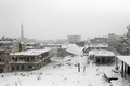 シリア北西部イドリブ県マーレトヌーマンの雪に覆われた廃虚（2016年12月21日撮影）。(c)AFP/Mohamed al-Bakour