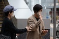 香港で、保釈され警察署を出る民主活動家で歌手の何韻詩（デニス・ホー）氏（右、2021年12月30日撮影）。(c)Bertha WANG / AFP