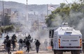 イスラエル北部クファルカナ（Kfar Kana）で、22歳の青年が警察に射殺された事件に抗議するアラブ系イスラエル人の若者たちと衝突するイスラエルの治安部隊（2014年11月9日撮影）。(c)AFP/JACK GUEZ