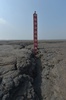 インドネシア・ジャワ島シドアルジョの泥火山地域に立つ泥の深さを示す指標（2016年3月28日撮影）。(c)AFP/ADEK BERRY