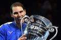 男子テニス、2019年シーズンの表彰式で年間1位のトロフィーをかむラファエル・ナダル（2019年11月15日撮影）。(c)Glyn KIRK / AFP