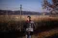 韓国と北朝鮮を隔てる軍事境界線沿いの非武装地帯（DMZ）近くで、父親の解放を求めるメッセージが書かれたプラカードを持つファン・インチョルさん（2019年12月8日撮影）。(c)AFP/Ed JONES / AFP