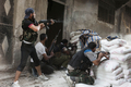 シリア北部アレッポ（Aleppo）のサラヘディン（Salaheddin）地区で政府軍と銃撃戦をする反体制派・自由シリア軍（Free Syrian Army、FSA）の戦闘員ら（2012年8月22日撮影）。(c)AFP/JAMES LAWLER DUGGAN