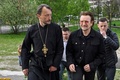 ウクライナの首都キーウ近郊ブチャで集団埋葬地を訪れたロックバンド「U2」のボノさん（前方右）を案内する教会の神父（2022年5月8日撮影）。(c)Genya SAVILOV / AFP