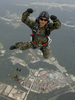 韓国・鶏龍（Gyeryong）の陸海空軍本部で前月29日、1日に61年を迎える「国軍の日（Armed Forces Day）」に向けたリハーサルが行われた。1950年～53年の朝鮮戦争で、韓国は1953年、北朝鮮と休戦協定を結んだが、法的には戦争状態にある。

写真は、鶏龍の陸海空軍本部で実施された「国軍の日」に向けた軍事演習で、上空のヘリコプターからパラシュート降下しながら、カメラに向かって親指を立てる韓国軍特殊部隊兵士（2009年9月29日撮影）。(c)AFP/JO YONG-HAK