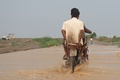 イエメン・ホデイダ州コーハ地区で、冠水した場所をバイクで通る人（2024年9月1日撮影）。(c)Khaled ZIAD / AFP