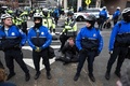米首都ワシントンで、デモ参加者を拘束する警官隊（2017年1月20日撮影）。(c)AFP/ZACH GIBSON