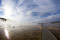 米イエローストーン国立公園（Yellowstone National Park）内のミッドウエーガイザーベイスン（Midway Geyser Basin）で、蒸気に包まれた遊歩道を歩く観光客。

1872年に米国初の国立公園として設立されたイエローストーンには、1万を超える間欠泉や泥間欠泉、蒸気孔、温泉がある。ワイオミング（Wyoming）、モンタナ（Montana）、アイダホ（Idaho）の3州にまたがり、公園名はイエローストーン川（Yellowstone River）にちなんでいる（2012年10月8日撮影）。(c)AFP/Karen BLEIER
