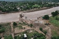 メキシコで19日、新たなハリケーンが北西部に上陸した。一連の暴風雨により発生した洪水や土砂崩れによる死者は合計で100人近くに上り、土砂に埋まった村では、新たな土砂崩れが起きる恐れがある中、行方不明になっている58人の捜索が行われている。

今週初めに太平洋岸を襲い、いったんは勢力を弱めていた熱帯低気圧「マヌエル（Manuel）」は、再び勢力を強めハリケーンに発達。北西部シナロア（Sinaloa）州に上陸して土砂崩れを引き起こし、ある漁村は避難を余儀なくされた。マヌエルはその後、熱帯性低気圧に戻った。

ルイス・フェリペ・プエンテ（Luis Felipe Puente）市民保護調整官によると、死者数は81人から97人に増え、うち65人は南西部ゲレロ（Guerrero）州で確認された。

メキシコでは今週、マヌエルの接近とほぼ同時に東岸にハリケーン「イングリッド（Ingrid）」が上陸、国土の大半に大雨を降らせ、橋や道路、住宅数万棟に被害をもたらした。中でもゲレロ州は最も大きな被害を受けている。

写真はゲレロ州アカプルコ（Acapulco）で大雨により流された橋を写した空撮写真（2013年9月19日撮影）。(c)AFP/Claudio VARGAS