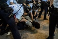 デモ隊と警官隊が衝突した香港（Hong Kong）の旺角（Mongkok）で、デモ参加者（中央）を取り押さえた警察官たち（2014年10月17日撮影）。(c)AFP/ANTHONY WALLACE