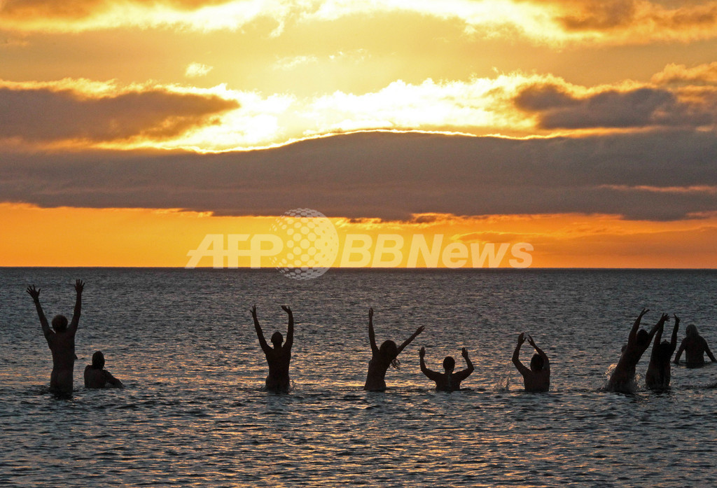 朝日を浴びて200人が全裸海水浴、英国 写真11枚 国際ニュース：AFPBB News
