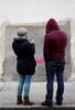 英国のグラフィティ（落書き）アーティスト、バンクシー（Banksy）氏がロンドン（London）市内の壁に描いた絵が、米国で競売にかけられることが分かったが、怒った住民たちの抗議によって競売への出品は中止されたと、地元自治体が24日、明らかにした。

写真は、バンクシー（Banksy）氏の壁画が持ち去られた後の壁を見つめる人たち（2013年2月23日撮影）。(c)AFP/JUSTIN TALLIS