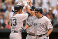 ボルティモア・オリオールズ（Baltimore Orioles）対ニューヨーク・ヤンキース（New York Yankees）。試合はヤンキースが4-0で勝利し、連敗を5で止めた。写真は1回に左翼へ3点本塁打を放ち、ジョニー・デーモン（Johnny Damon、右）、マーク・テシェーラ（Mark Teixeira、中央）とハイタッチを交わすヤンキースのアレックス・ロドリゲス（Alex Rodriguez）。（2009年5月8日撮影）(c)AFP/Getty Images/Mitchell Layton