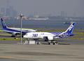 全日本空輸（All Nippon Airways、ANA）に25日引き渡された米航空機大手ボーイング（Boeing）の新世代旅客機「ボーイング787ドリームライナー（Boeing 787 Dreamliner）」1号機が28日、東京・羽田空港に到着した。

前日、明け方の曇り空のもと、予定より45分遅れで米ワシントン（Washington）州エバレット（Everett）のペインフィールド（Paine Field）空港を離陸した787は28日午前9時過ぎ、羽田空港に到着。多くの報道陣、航空ファンらに迎えられた。

1機平均2億200万ドル（約155億円）、乗客定員は330席。当初の予定では2008年初めに最初の機体が全日空に納入される予定だった。ボーイングにとってドリームライナーは、軽量化を図った中型旅客機の成功を賭けた存在でもある。

全日空は来月26日、成田発香港行きの便で、787を世界で初めて導入する。その後、羽田－北京（Beijing）や羽田－フランクフルト（Frankfurt）線でも運航していく。

写真は東京・羽田空港に到着した全日本空輸のボーイング787ドリームライナー1号機（2011年9月28日撮影）。(c)AFP/Yoshikazu TSUNO