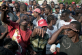 ハイチの首都ポルトープランス（Port-au-Prince）で、崩壊した大統領官邸前で、フェンスの内側に姿を現したルネ・プレバル（Rene Preval）ハイチ大統領に向かって叫ぶ市民（2010年1月30日撮影）。(c)AFP/JEAN-PHILIPPE KSIAZEK