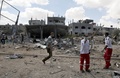 パレスチナ自治区ガザ地区（Gaza Strip）南部ラファ（Rafah）の難民キャンプ近くで、イスラエル軍の攻撃による負傷者などを探す救助隊員（2014年8月4日撮影）。(c)AFP/MAHMUD HAMS