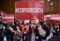 米首都ワシントンで、ニール・ゴーサッチ氏の連邦最高裁判事指名に反対する民主党議員らが開いた記者会見でプラカードを掲げる活動家ら（2017年4月6日撮影）。(c)AFP/MANDEL NGAN