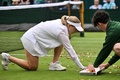 テニス、ウィンブルドン選手権、女子シングルス1回戦。コートにまかれた紙吹雪を拾い集めるダリア・サビル（左）とボールキッズ（2023年7月5日撮影）。(c)Glyn KIRK / AFP