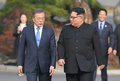 韓国と北朝鮮の軍事境界線上の板門店で並んで歩く韓国の文在寅（ムン・ジェイン）大統領（左）と北朝鮮の金正恩（キム・ジョンウン）朝鮮労働党委員長（2018年4月27日撮影）。(c)AFP PHOTO / Korea Summit Press Pool / Korea Summit Press Pool