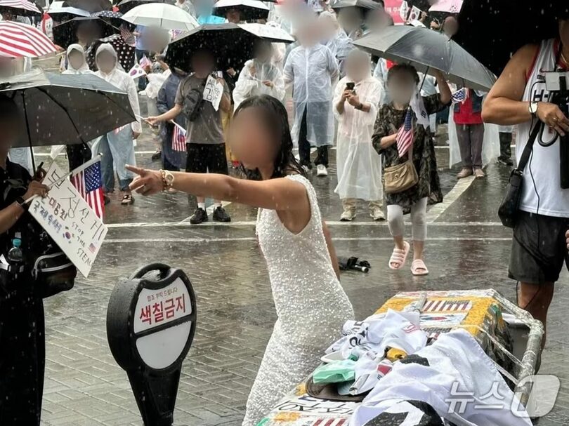 22日、オリンピック公園ハンドボール競技場前で、40代女性が現場に配置された警察官に向かって指さしている(c)news1